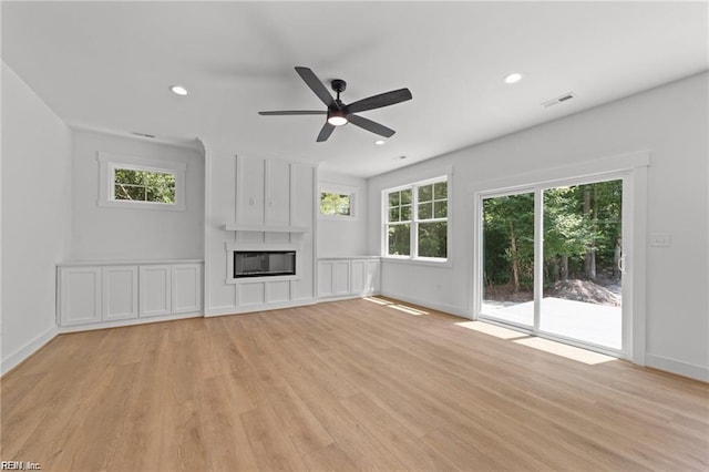 unfurnished living room featuring a fireplace, light hardwood / wood-style floors, and ceiling fan