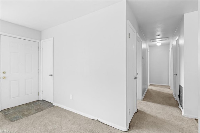 hallway featuring light colored carpet