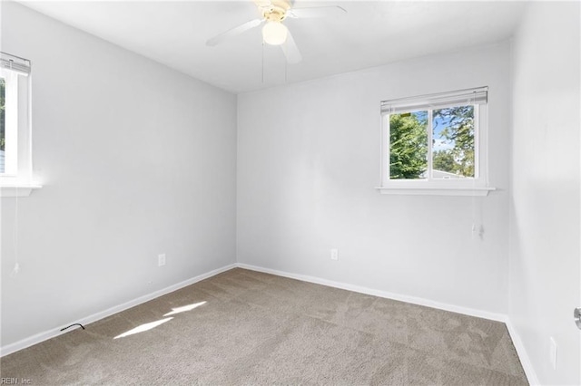 carpeted spare room featuring ceiling fan