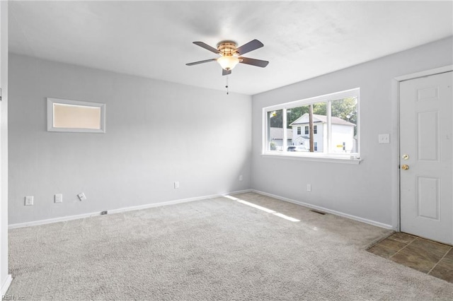 carpeted spare room with ceiling fan