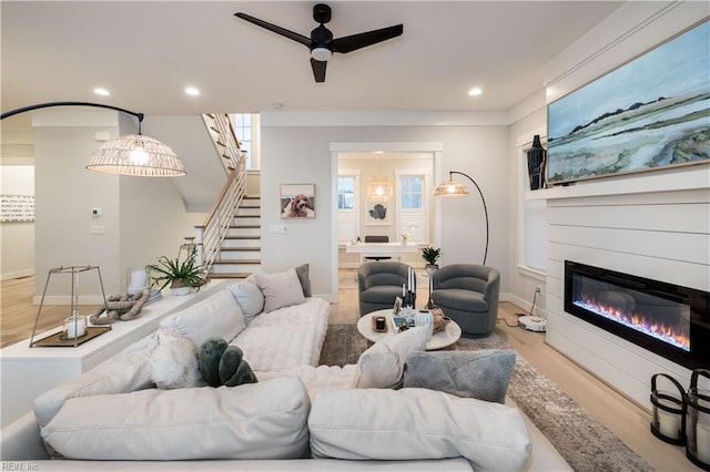 living room with ceiling fan and light wood-type flooring