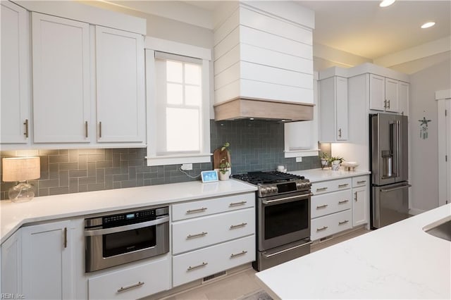 kitchen featuring white cabinetry, stainless steel appliances, and decorative backsplash