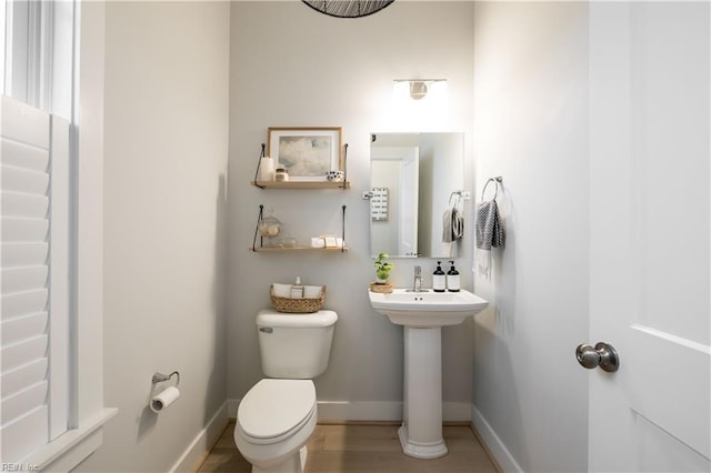 bathroom featuring wood-type flooring and toilet