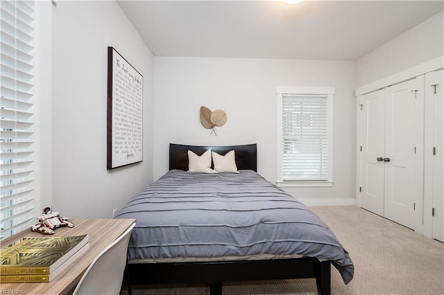 bedroom with light carpet and a closet