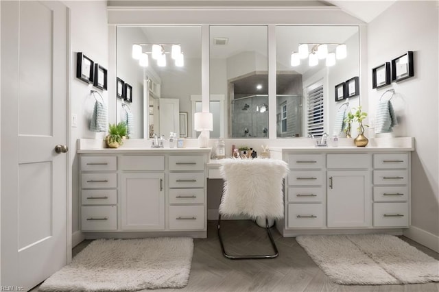 bathroom with parquet flooring, vanity, and an enclosed shower