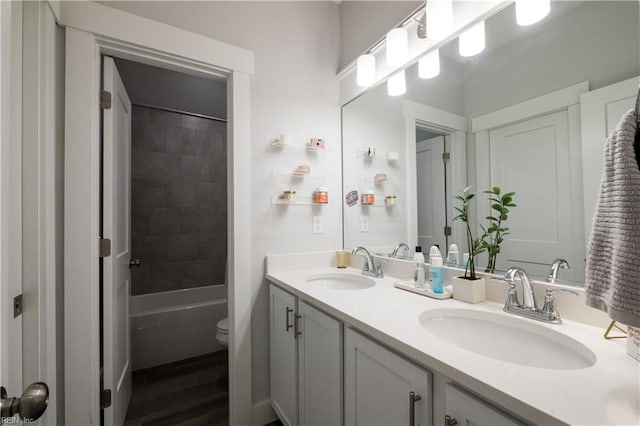 full bathroom with vanity, tiled shower / bath combo, toilet, and hardwood / wood-style flooring