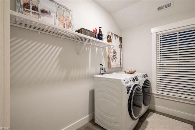 washroom with hardwood / wood-style flooring and washer and clothes dryer