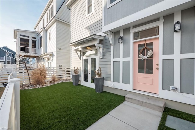 view of exterior entry featuring french doors and a yard