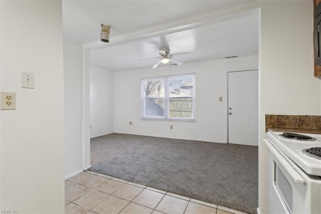 kitchen with electric stove, light colored carpet, and ceiling fan