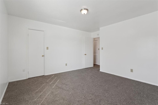 empty room featuring dark colored carpet