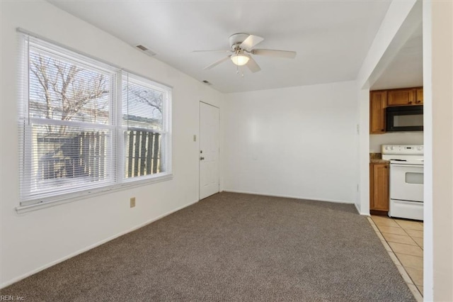 interior space featuring light carpet and ceiling fan