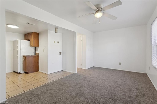 unfurnished living room featuring ceiling fan and light colored carpet