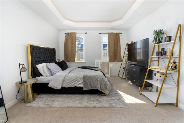 bedroom with ornamental molding, a tray ceiling, and carpet