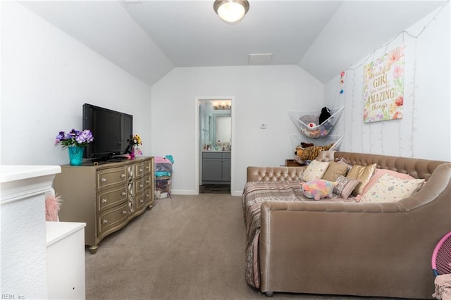 carpeted bedroom featuring lofted ceiling and ensuite bathroom