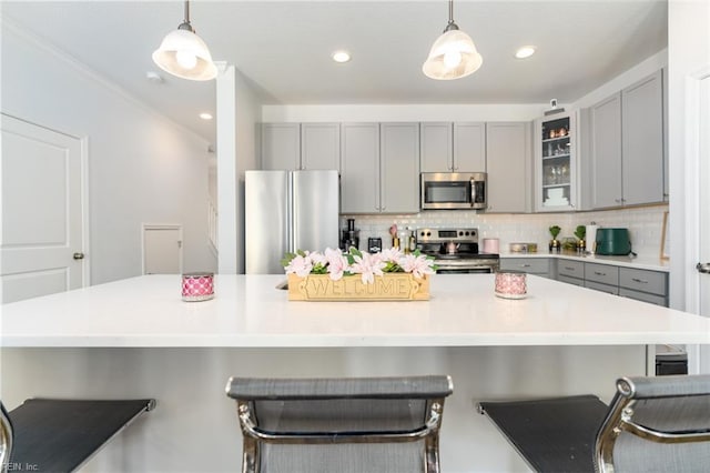 kitchen with pendant lighting, a kitchen bar, and appliances with stainless steel finishes