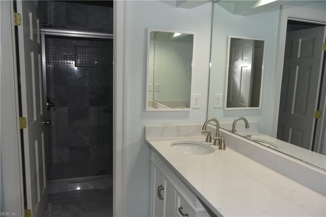 bathroom featuring vanity and a shower with door