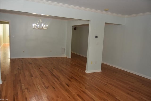 unfurnished room featuring ornamental molding, a chandelier, and hardwood / wood-style floors