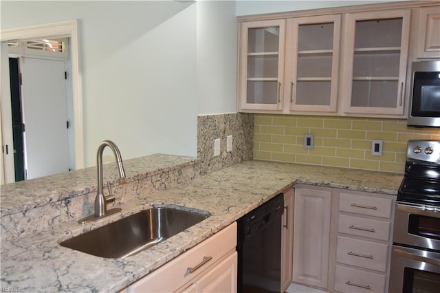 kitchen with appliances with stainless steel finishes, sink, backsplash, and light stone counters