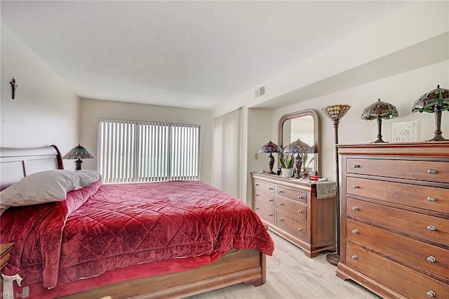 bedroom featuring light hardwood / wood-style flooring and a textured ceiling