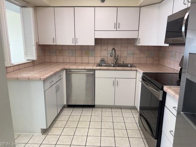 kitchen with white cabinetry, appliances with stainless steel finishes, sink, and decorative backsplash