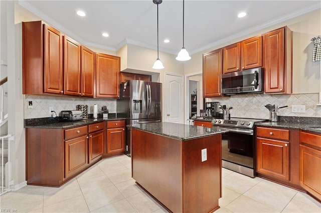 kitchen with a kitchen island, appliances with stainless steel finishes, dark stone countertops, hanging light fixtures, and ornamental molding