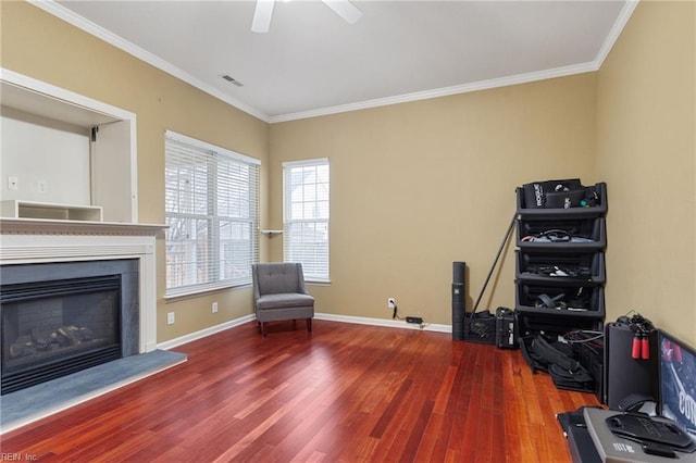 living area featuring ceiling fan, ornamental molding, and wood-type flooring