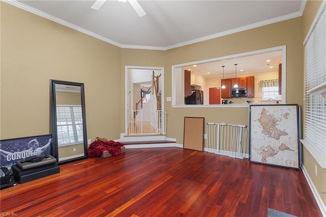 unfurnished living room featuring hardwood / wood-style floors, crown molding, and plenty of natural light