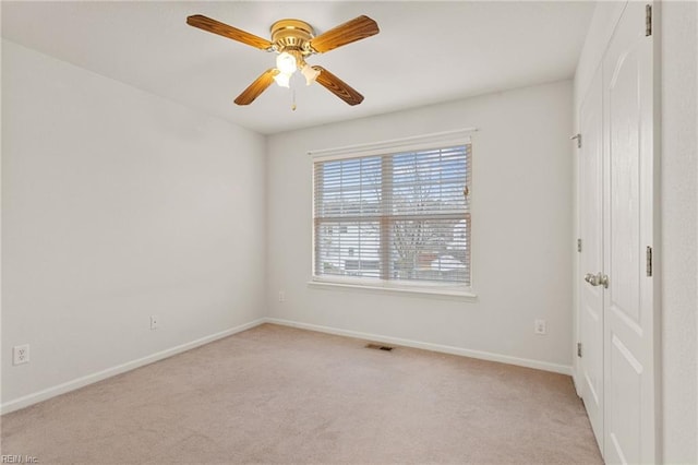 carpeted spare room featuring ceiling fan