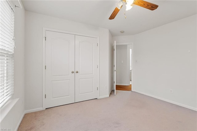 unfurnished bedroom featuring light carpet, a closet, and ceiling fan