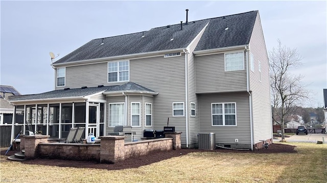 back of property with a yard, a sunroom, and a patio