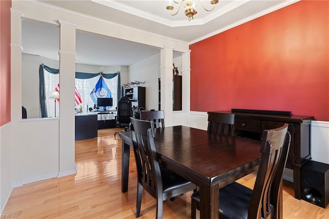 dining area with ornamental molding, a chandelier, light hardwood / wood-style flooring, and ornate columns