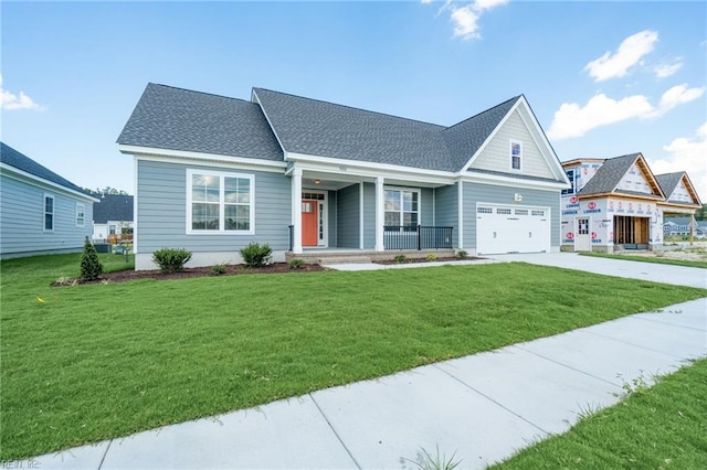 view of front of property featuring a garage, a front yard, and covered porch