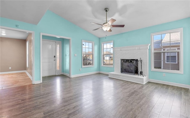 unfurnished living room with hardwood / wood-style flooring, ceiling fan, lofted ceiling, and a brick fireplace