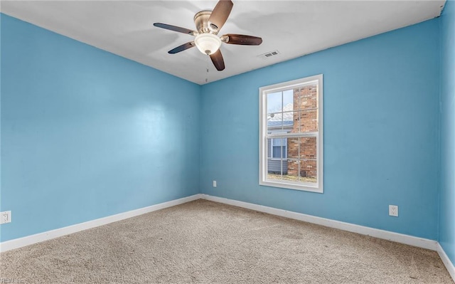 unfurnished room with ceiling fan and carpet