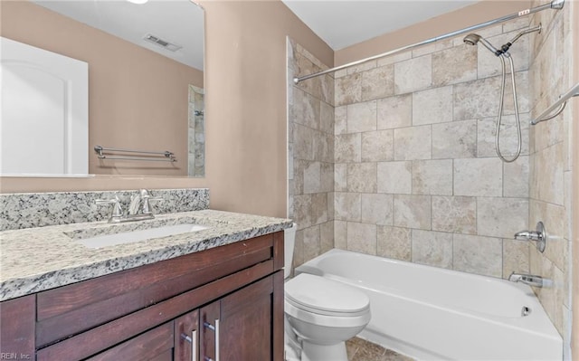 full bathroom with vanity, tiled shower / bath, and toilet