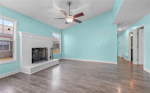 unfurnished living room with vaulted ceiling, a brick fireplace, ceiling fan, and dark hardwood / wood-style flooring