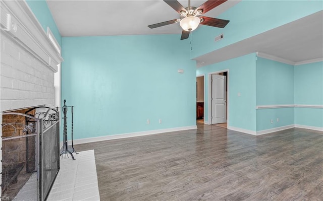 unfurnished living room featuring a brick fireplace, hardwood / wood-style flooring, ornamental molding, and ceiling fan