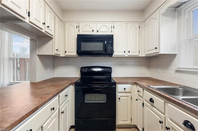 kitchen with butcher block countertops, decorative backsplash, black appliances, and white cabinets