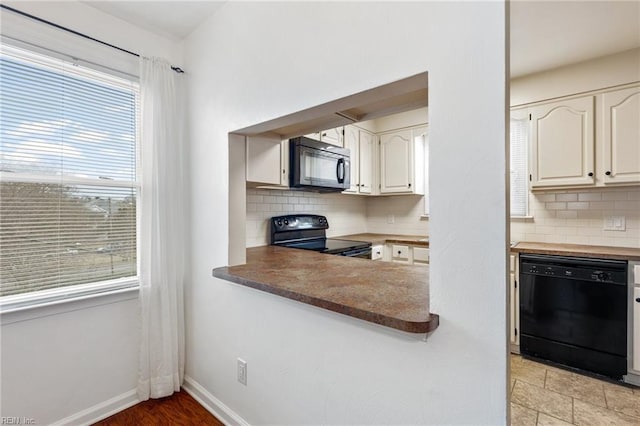 kitchen featuring tasteful backsplash, black appliances, and white cabinets