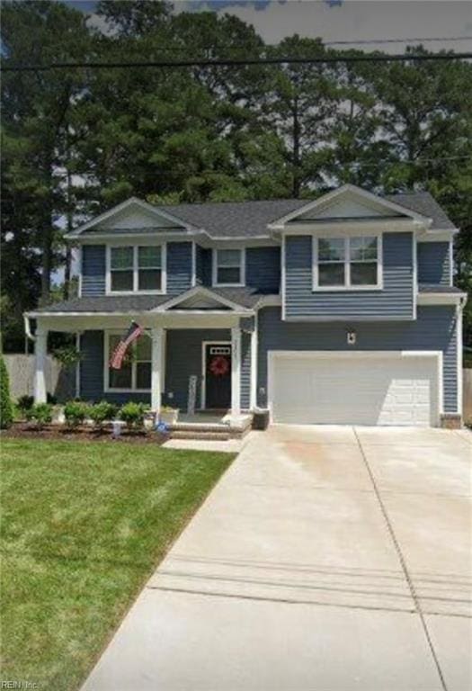 view of front of property with a garage, a front lawn, and a porch