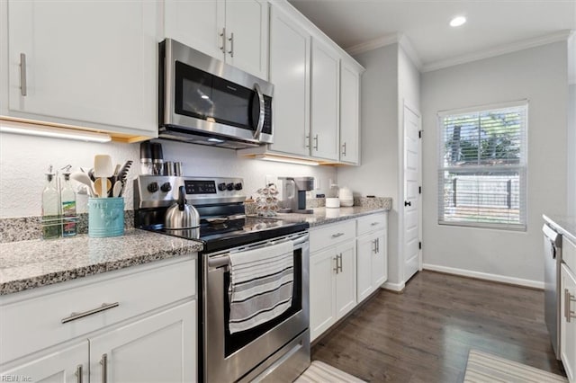 kitchen with dark hardwood / wood-style floors, white cabinets, ornamental molding, stainless steel appliances, and light stone countertops