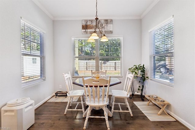 dining area featuring dark wood-type flooring, ornamental molding, and a notable chandelier