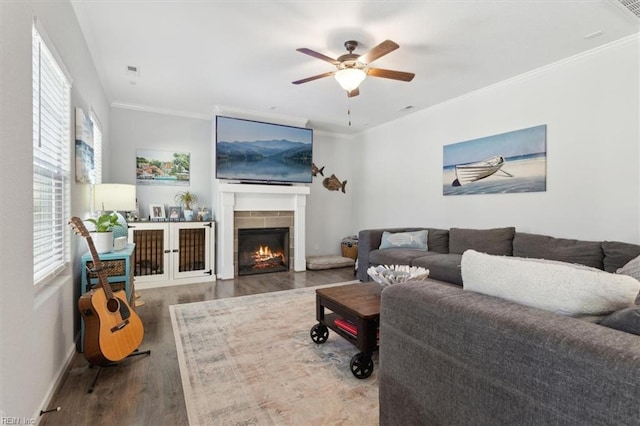 living room featuring wood-type flooring, ornamental molding, and ceiling fan