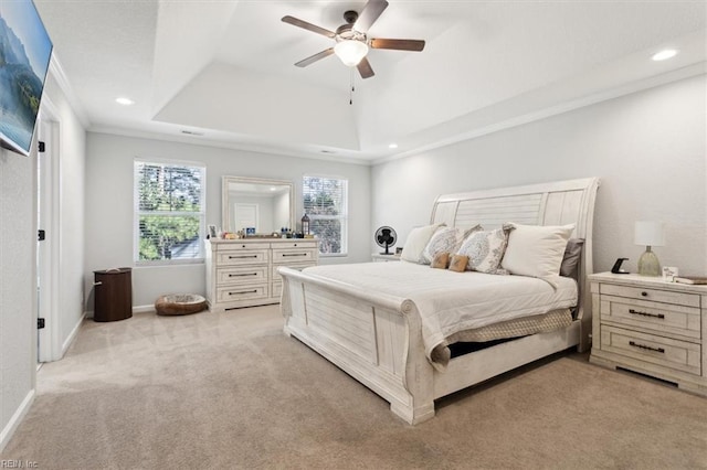 bedroom with crown molding, light colored carpet, ceiling fan, and a tray ceiling