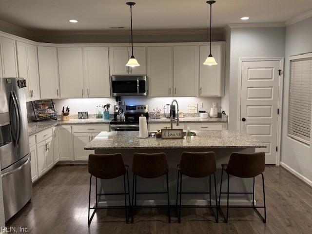 kitchen with crown molding, a center island with sink, white cabinets, and appliances with stainless steel finishes