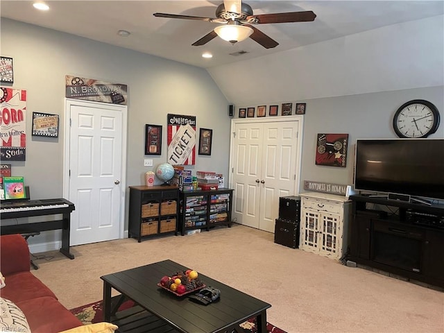 living room with ceiling fan, lofted ceiling, and light carpet