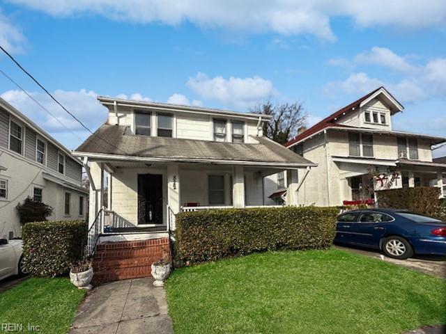 bungalow-style home with a front yard and covered porch