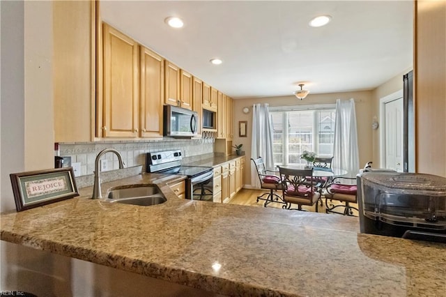 kitchen featuring sink, backsplash, stainless steel appliances, light stone counters, and light brown cabinets