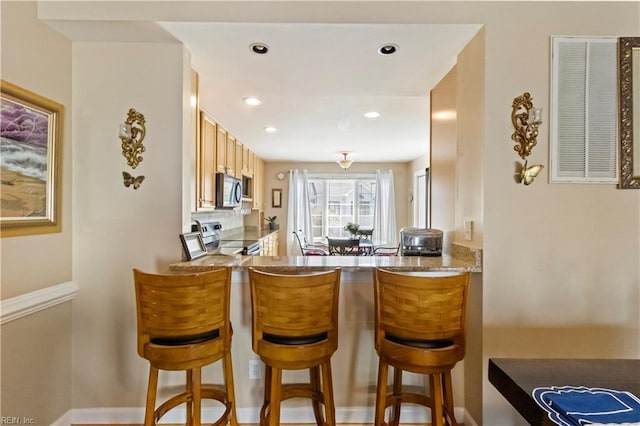 bar featuring tasteful backsplash and appliances with stainless steel finishes