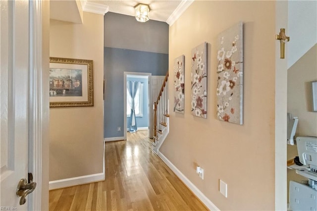 hallway featuring ornamental molding and light hardwood / wood-style floors